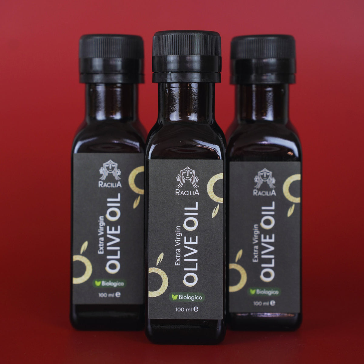 Coffret de 3 bouteilles d'huile d'olive vierge extra bio Racilia 100 ml sur fond rouge